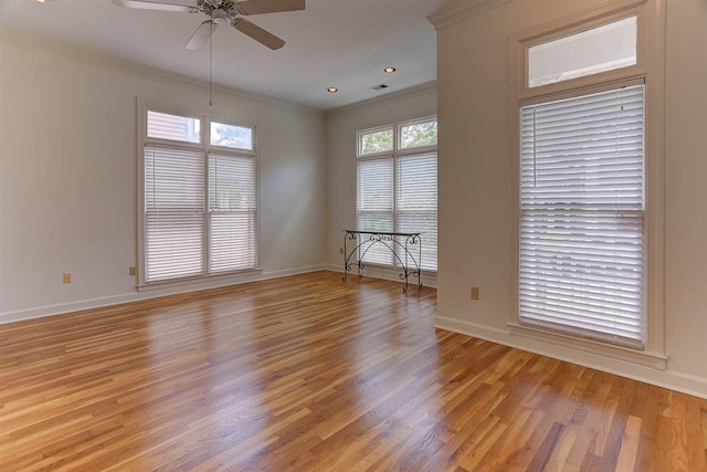 unfurnished room with crown molding, a ceiling fan, light wood-style flooring, and baseboards
