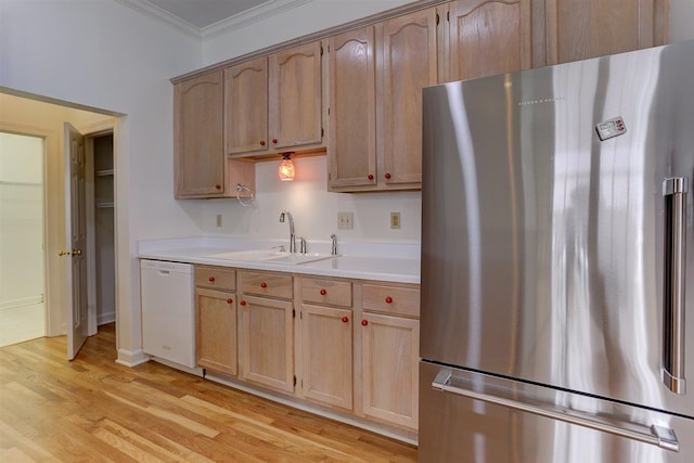 kitchen with crown molding, freestanding refrigerator, light countertops, a sink, and dishwasher