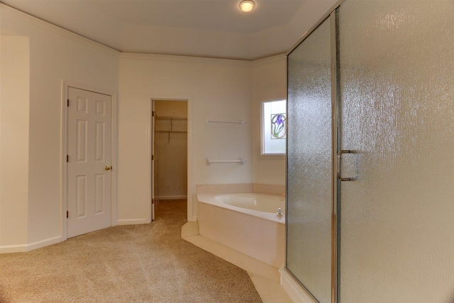 bathroom with carpet floors, a walk in closet, a bath, and a stall shower