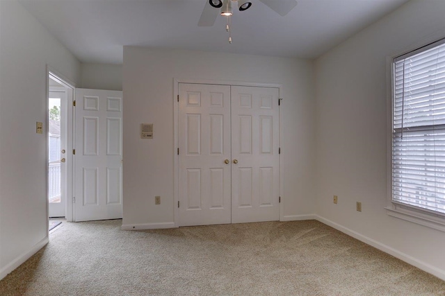 unfurnished bedroom featuring carpet flooring, multiple windows, and a closet