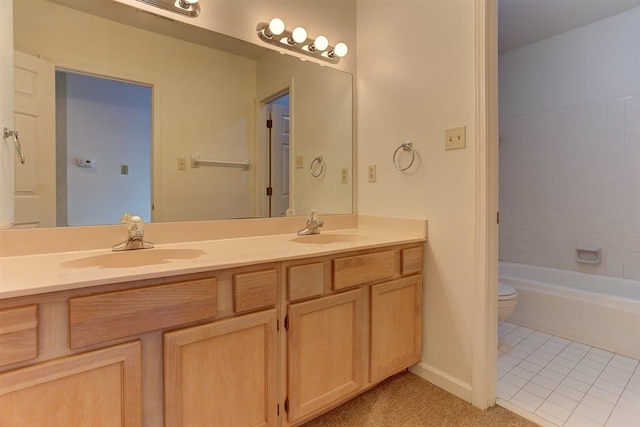 bathroom featuring double vanity, a sink, tile patterned floors, and toilet