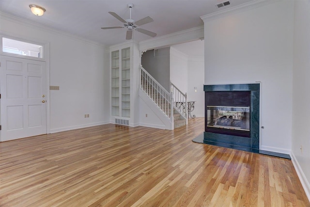 unfurnished living room featuring baseboards, stairs, and wood finished floors