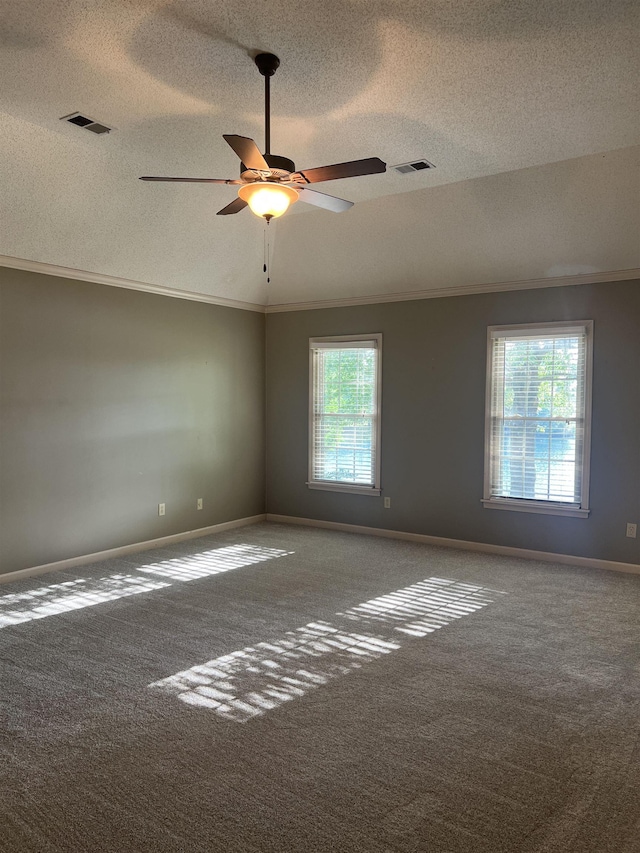empty room featuring carpet floors, a textured ceiling, visible vents, and ornamental molding