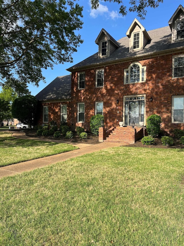view of front of property with a front lawn and brick siding