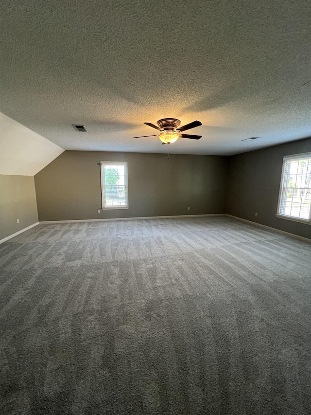 bonus room featuring a ceiling fan, a textured ceiling, visible vents, baseboards, and carpet