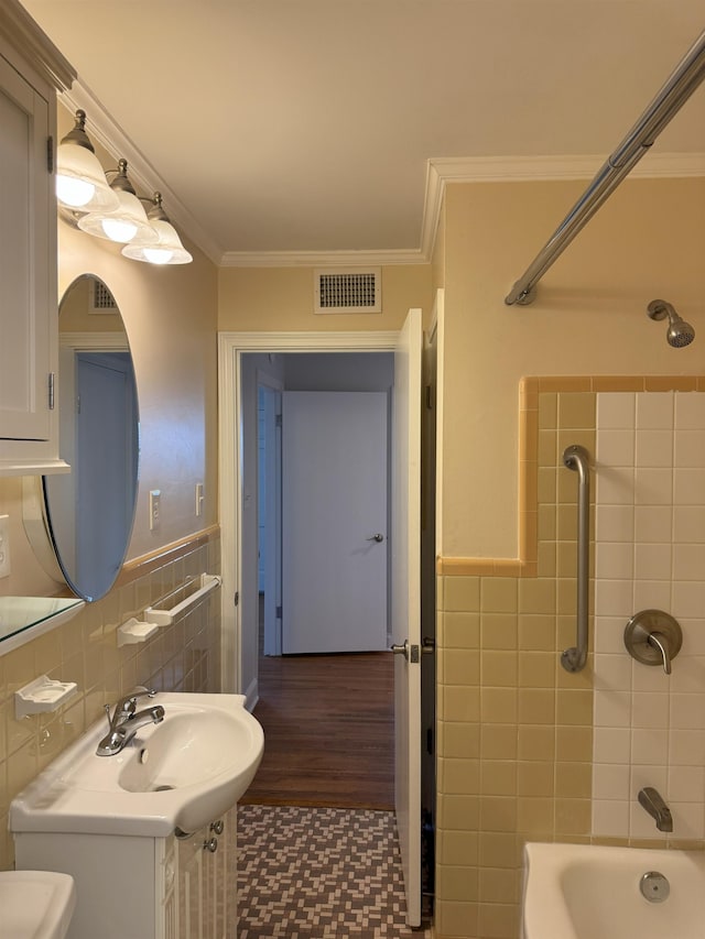 bathroom featuring tile walls, ornamental molding, shower / bath combination, and vanity