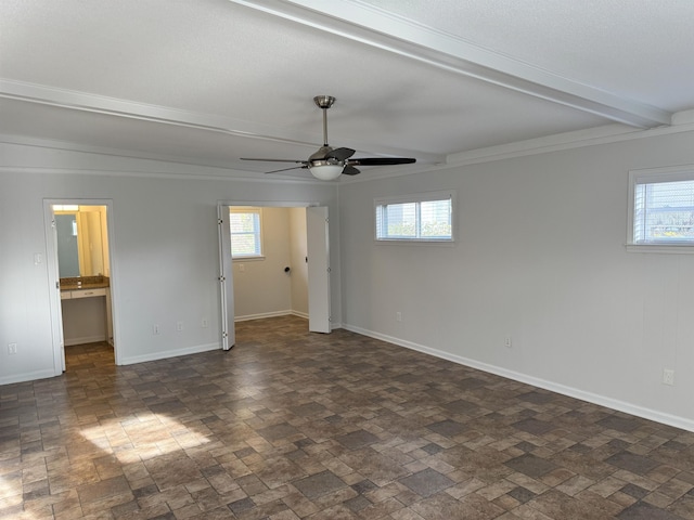 unfurnished bedroom with multiple windows, beamed ceiling, baseboards, and a ceiling fan