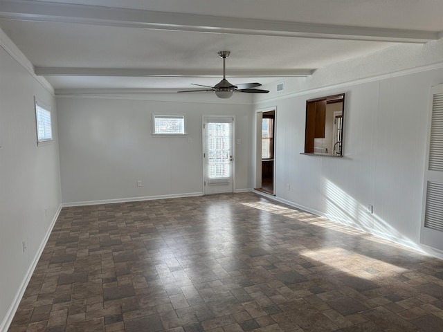 unfurnished living room featuring beamed ceiling, ceiling fan, baseboards, and dark stone finish floors