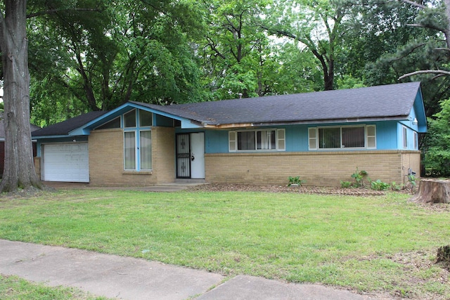 view of front of home featuring a garage, a front lawn, and brick siding