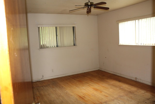 unfurnished room featuring ceiling fan, baseboards, and light wood-style floors