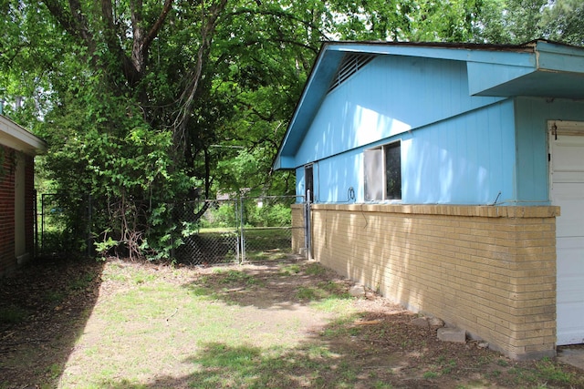 view of home's exterior featuring fence and brick siding