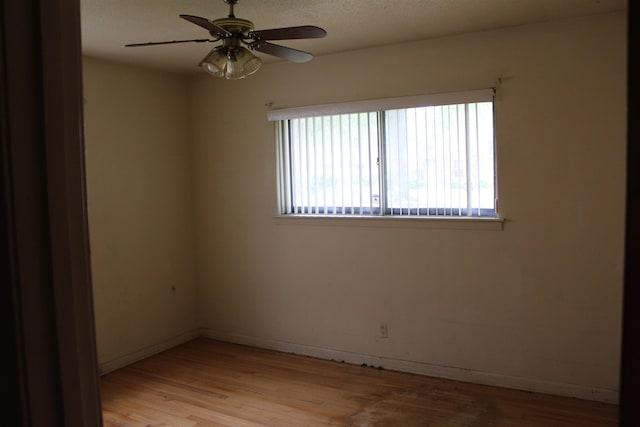 unfurnished room with baseboards, ceiling fan, and light wood finished floors