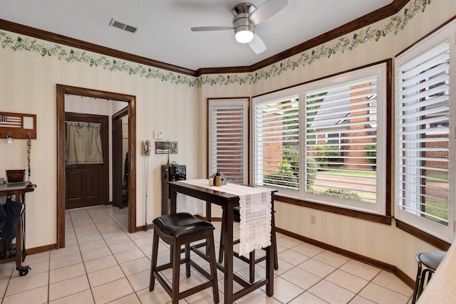 dining space featuring light tile patterned floors, visible vents, baseboards, ceiling fan, and ornamental molding