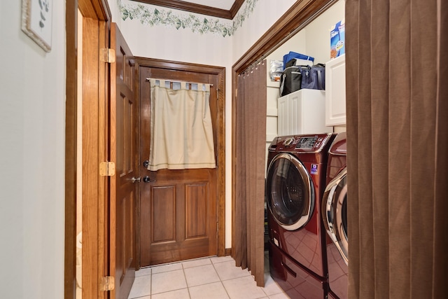 washroom with crown molding, separate washer and dryer, light tile patterned flooring, and cabinet space