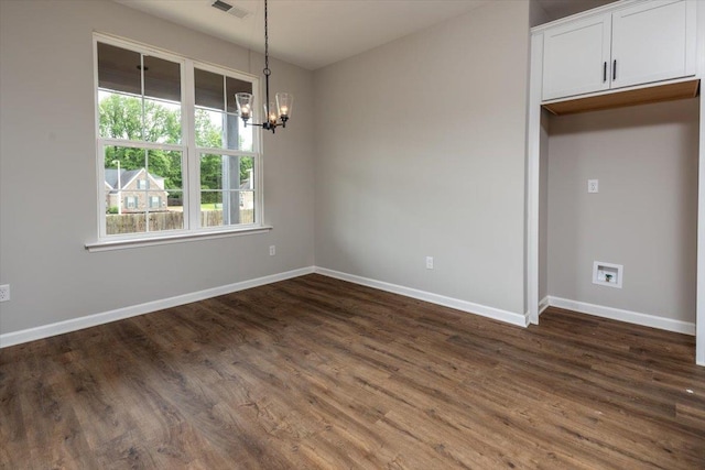 unfurnished dining area featuring baseboards, a notable chandelier, and dark wood-type flooring