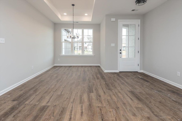 interior space with an inviting chandelier, baseboards, dark wood-type flooring, and a healthy amount of sunlight