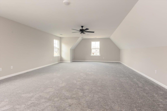 bonus room with lofted ceiling, carpet flooring, baseboards, and a ceiling fan