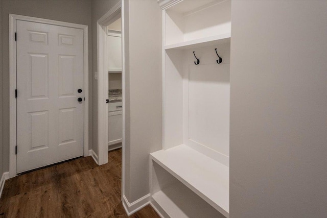mudroom featuring baseboards and dark wood-type flooring
