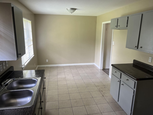 2997 Atmore St, Memphis, TN 38118 - kitchen featuring a sink, baseboards, dark countertops, and light tile patterned floors