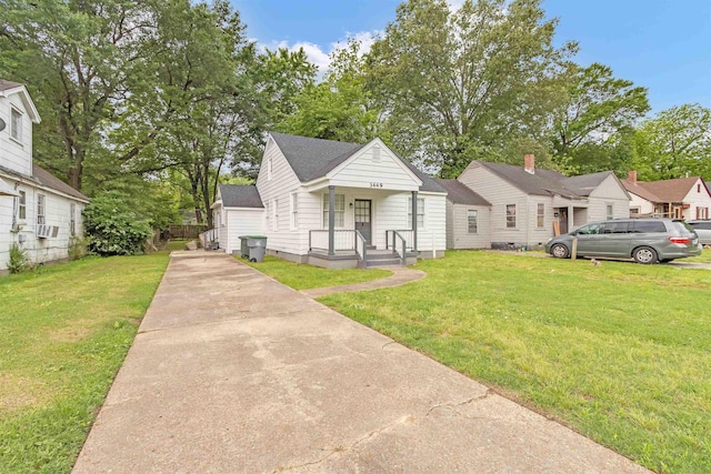 bungalow-style home featuring a shingled roof, a front lawn, cooling unit, and driveway