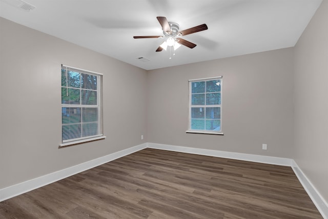 unfurnished room featuring ceiling fan, visible vents, baseboards, and dark wood-type flooring