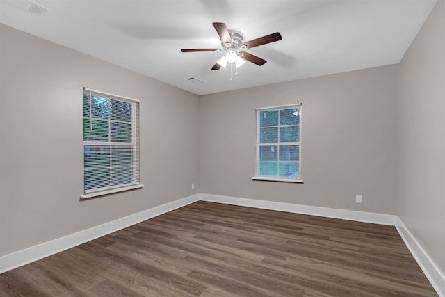 empty room featuring baseboards, ceiling fan, visible vents, and wood finished floors