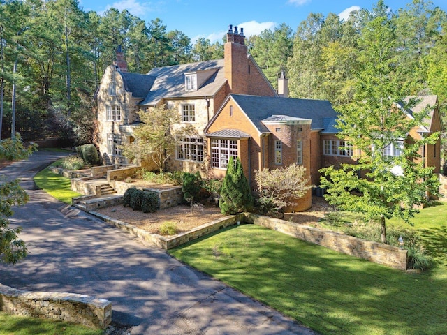 75 Notting Creek Cv, Eads, TN 38028 - tudor-style house with stone siding, a chimney, and a front yard