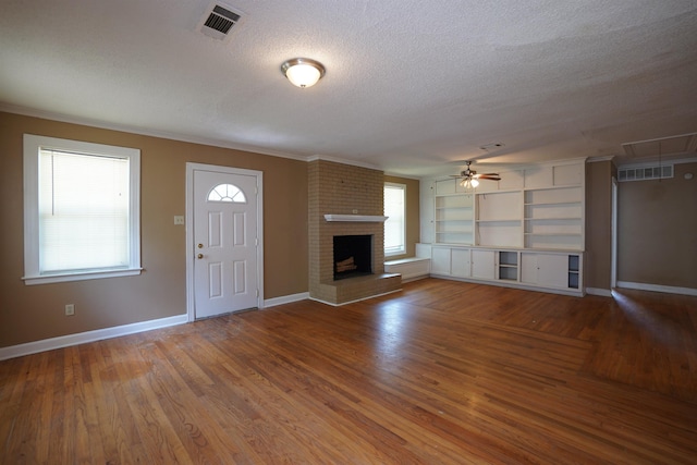 784 Juliet Ave, Memphis, TN 38127 - unfurnished living room featuring wood finished floors, a textured ceiling, ceiling fan, a brick fireplace, and baseboards