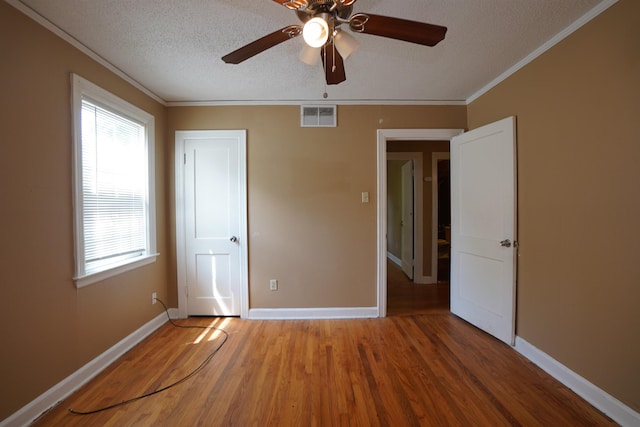 784 Juliet Ave, Memphis, TN 38127 - unfurnished bedroom with crown molding, visible vents, a textured ceiling, and wood finished floors