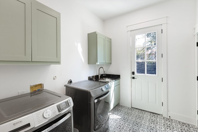 laundry area featuring a sink, light floors, cabinet space, and independent washer and dryer