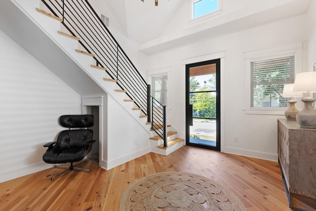 entrance foyer featuring baseboards, stairs, visible vents, and light wood-type flooring