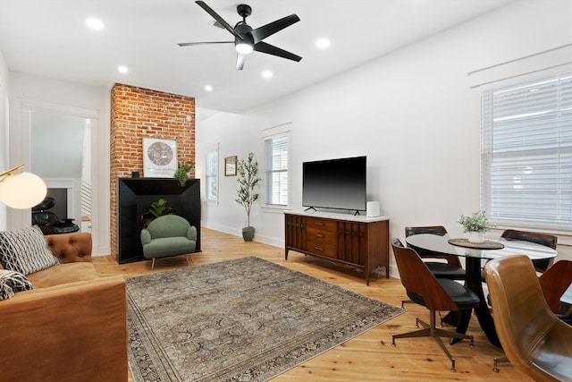 living room with baseboards, light wood-style flooring, a ceiling fan, and recessed lighting