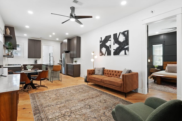 living room with ceiling fan, recessed lighting, light wood-style flooring, and visible vents