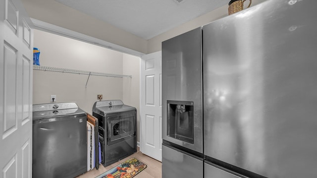 washroom featuring independent washer and dryer, light wood-style flooring, and laundry area