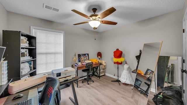 office area featuring wood finished floors, a textured ceiling, visible vents, ceiling fan, and baseboards