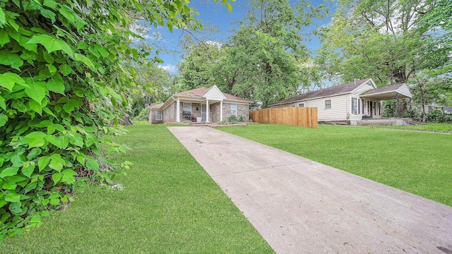 bungalow featuring concrete driveway, a front lawn, and fence