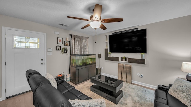 living room featuring baseboards, a ceiling fan, visible vents, and wood finished floors