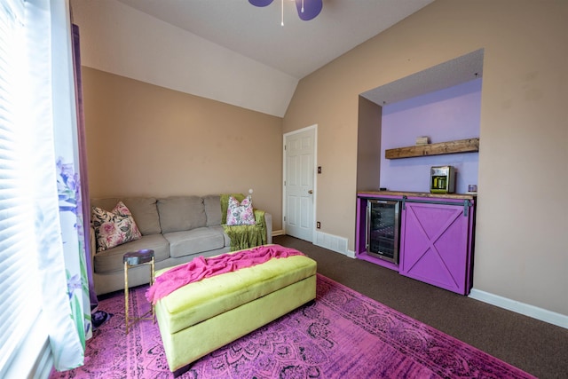 living area featuring beverage cooler, dark carpet, visible vents, baseboards, and lofted ceiling