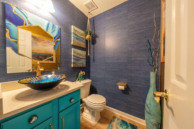 bathroom with toilet, baseboards, visible vents, tile patterned floors, and vanity