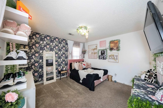 bedroom with wallpapered walls, a textured ceiling, baseboards, visible vents, and carpet floors