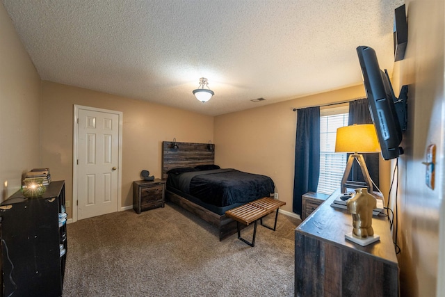bedroom featuring carpet flooring, a textured ceiling, visible vents, and baseboards