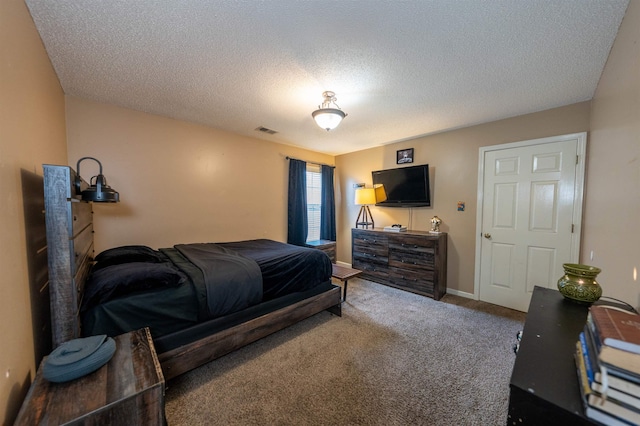 carpeted bedroom featuring a textured ceiling and visible vents