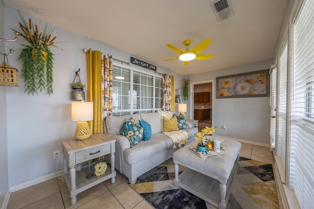 living room with light tile patterned floors, visible vents, baseboards, and ceiling fan
