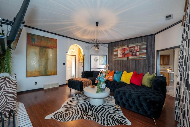 living room with ornamental molding, visible vents, wood finished floors, and arched walkways