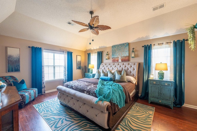 bedroom with wood finished floors, visible vents, a textured ceiling, and vaulted ceiling