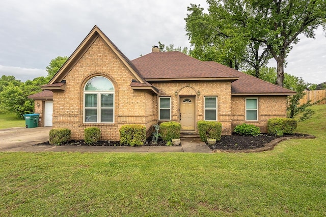 view of front of home with a shingled roof, a front lawn, and brick siding