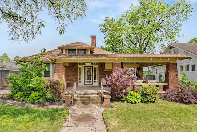 158 N Willett St, Memphis, TN 38104 - view of front facade featuring a chimney, a porch, a front yard, brick siding, and roof with shingles