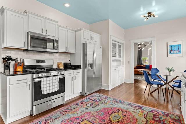 158 N Willett St, Memphis, TN 38104 - kitchen featuring a chandelier, dark wood-type flooring, dark countertops, stainless steel appliances, and white cabinets