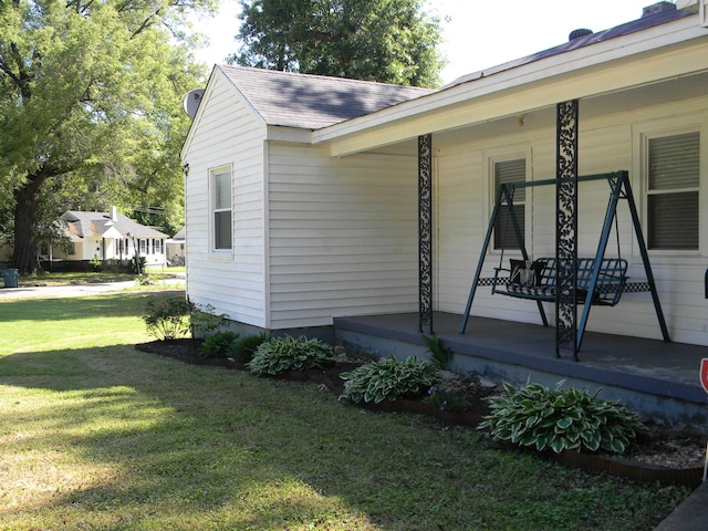 496 Eastern Dr SW, Memphis, TN 38122 - view of property exterior with covered porch, roof with shingles, and a lawn