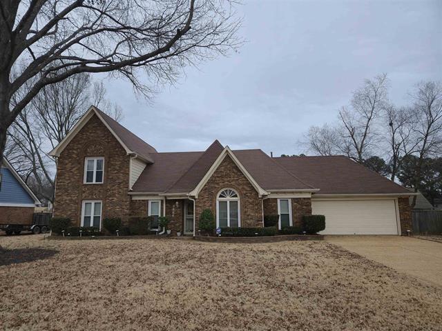 traditional-style house with concrete driveway, a garage, and brick siding